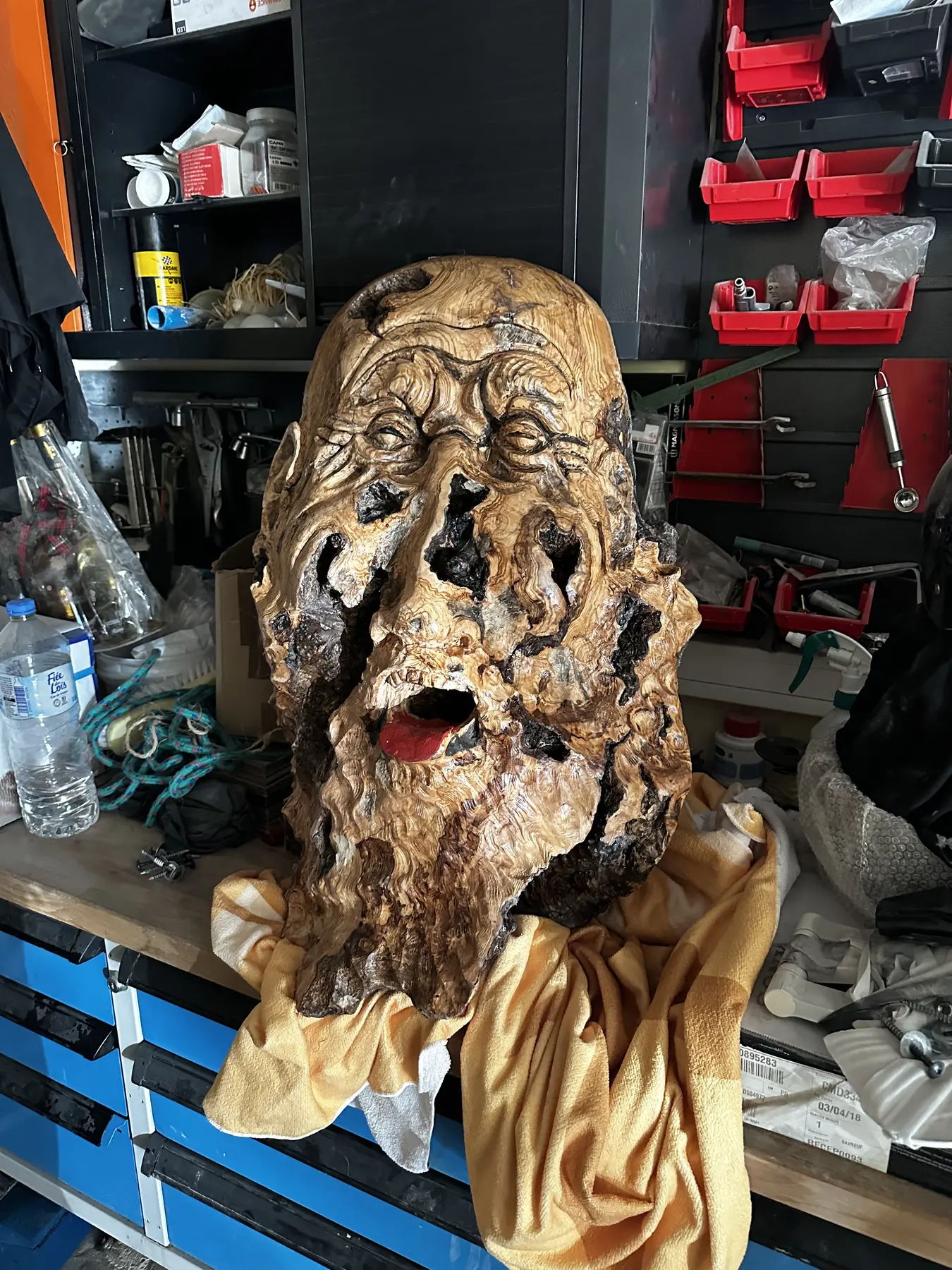 Œuvre achevée : visage sculpté dans une pièce d’olivier